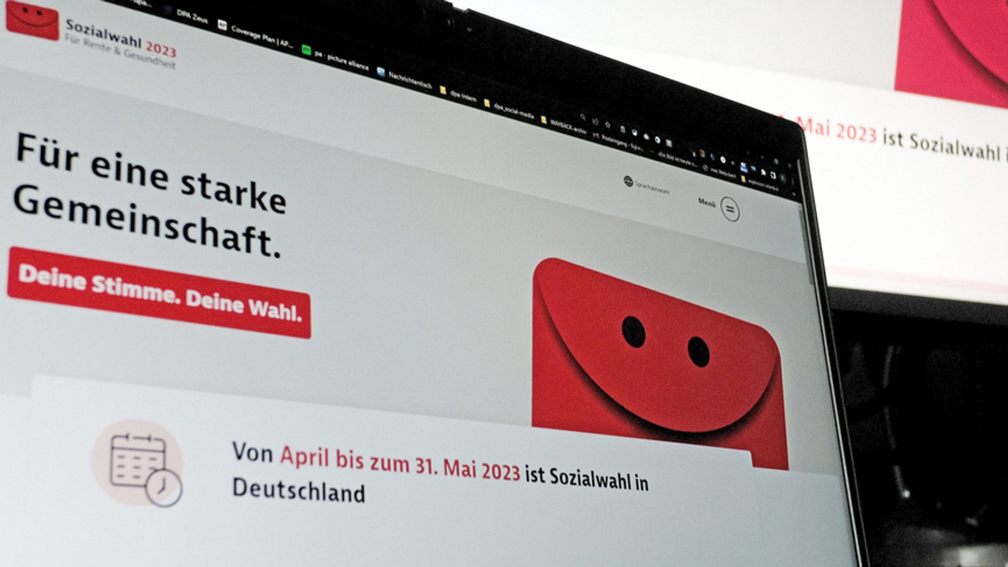 Eine Internetseite zur Sozialwahl 2023 ist auf zwei Computermonitoren zu sehen.