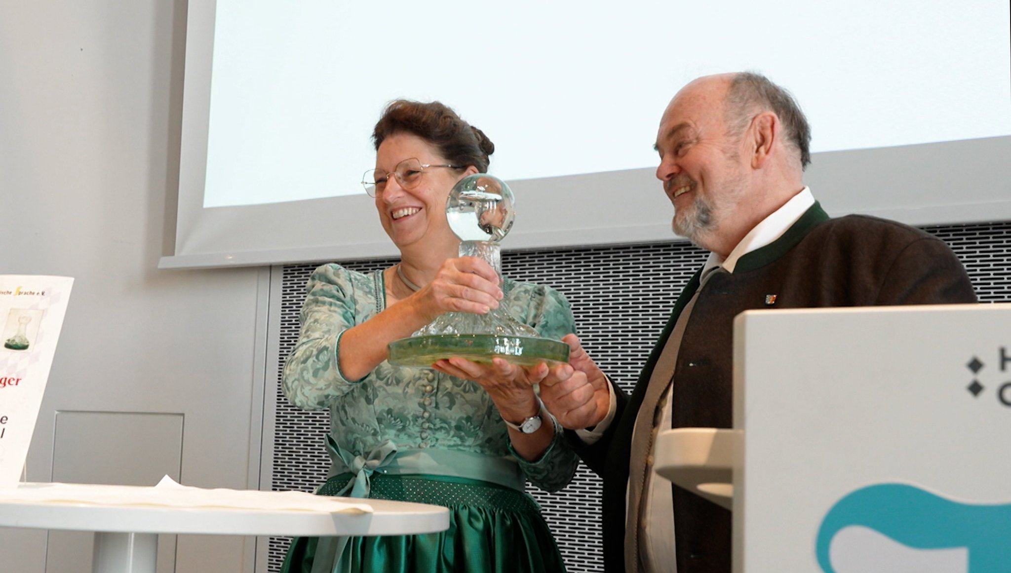 Die Europaabgeordnete und Landesbäuerin Christine Singer bekommt den Preis von "Sprachwurzel“-Erfinder Sepp Obermeier überreicht | Bild: BR Die Europaabgeordnete und Landesbäuerin Christine Singer bekommt den Preis von "Sprachwurzel“-Erfinder Sepp Obermeier überreicht