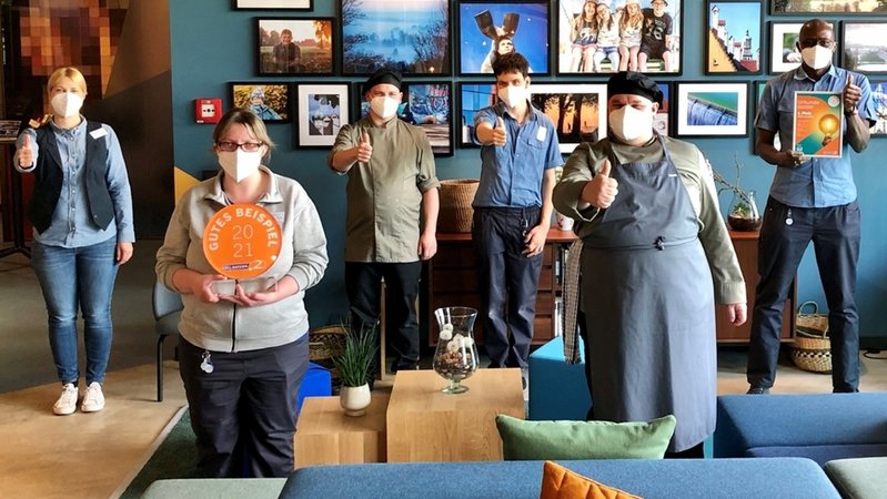 Mitarbeiterinnen und Mitarbeiter im Hotel "einsmehr" mit dem Pokal fürs "Gute Beispiel 2021"