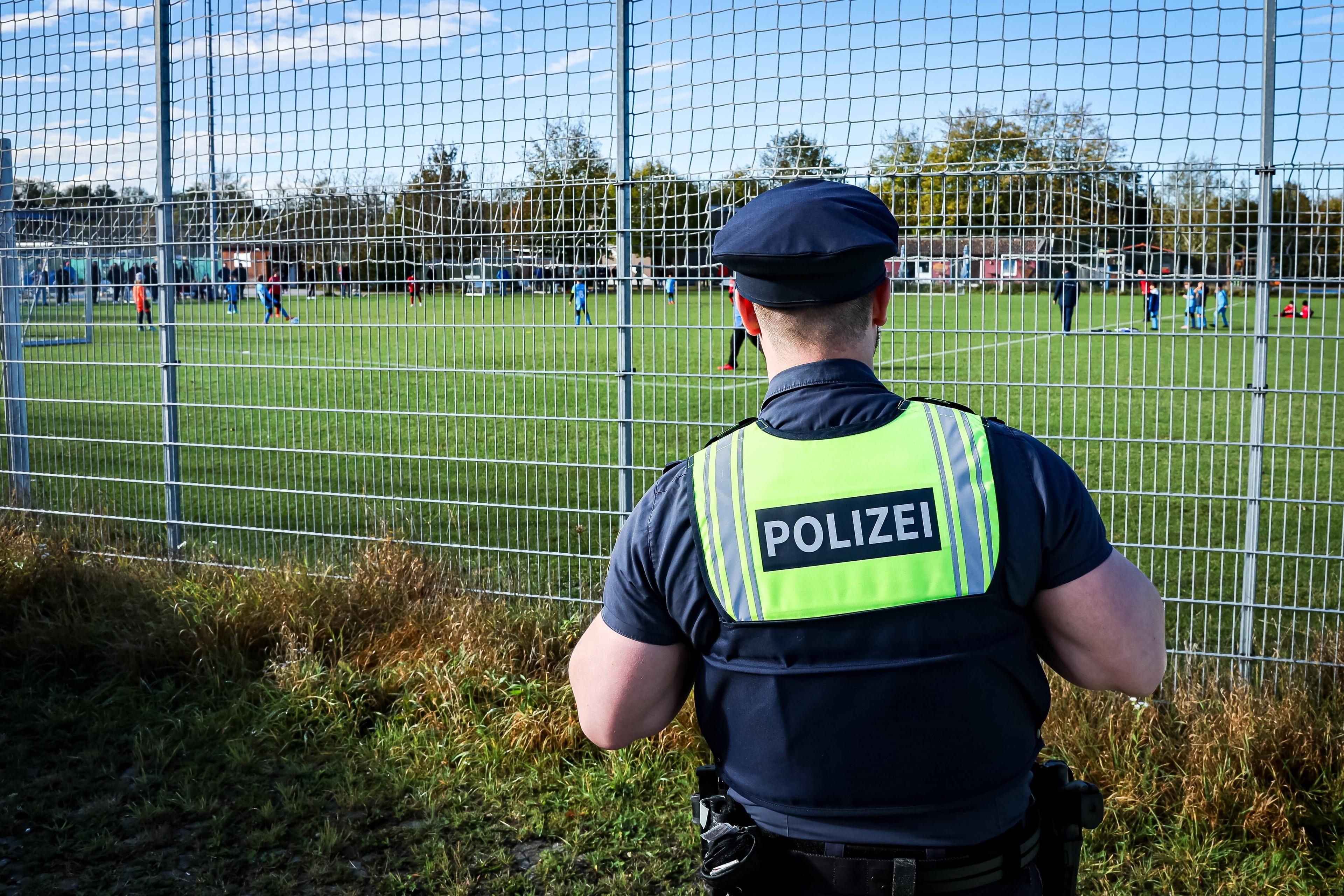 Polizist neben dem Fußball-Platz 