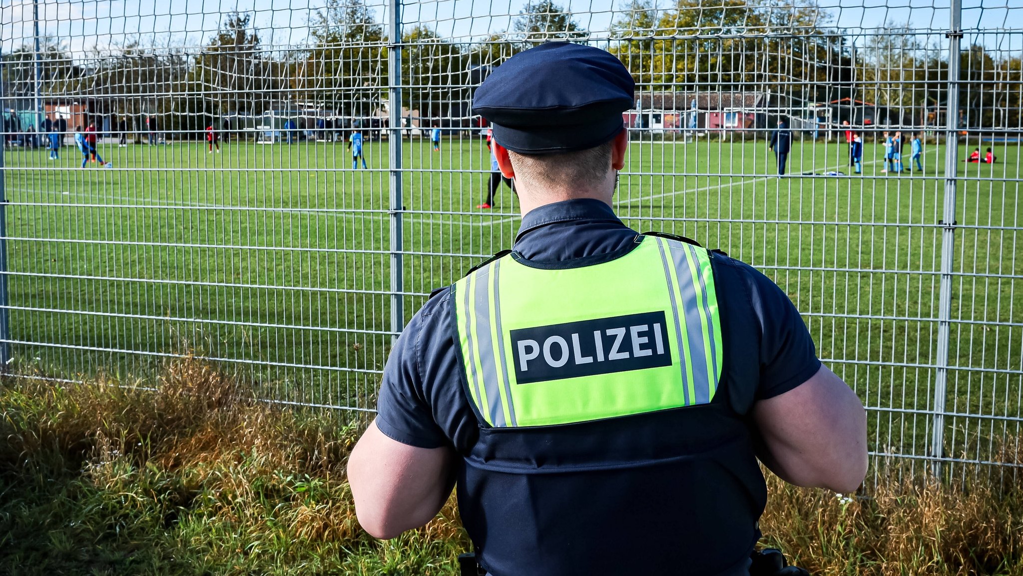 Polizist neben dem Fußball-Platz 