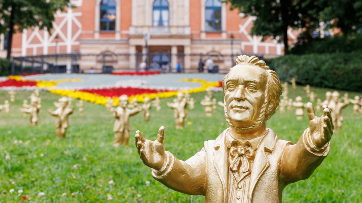 Goldfarbene Wagner-Figuren des Konzeptkünstler Ottmar Hörl stehen im Rahmen einer Kunstinstallation vor dem Festspielhaus in Bayreuth.