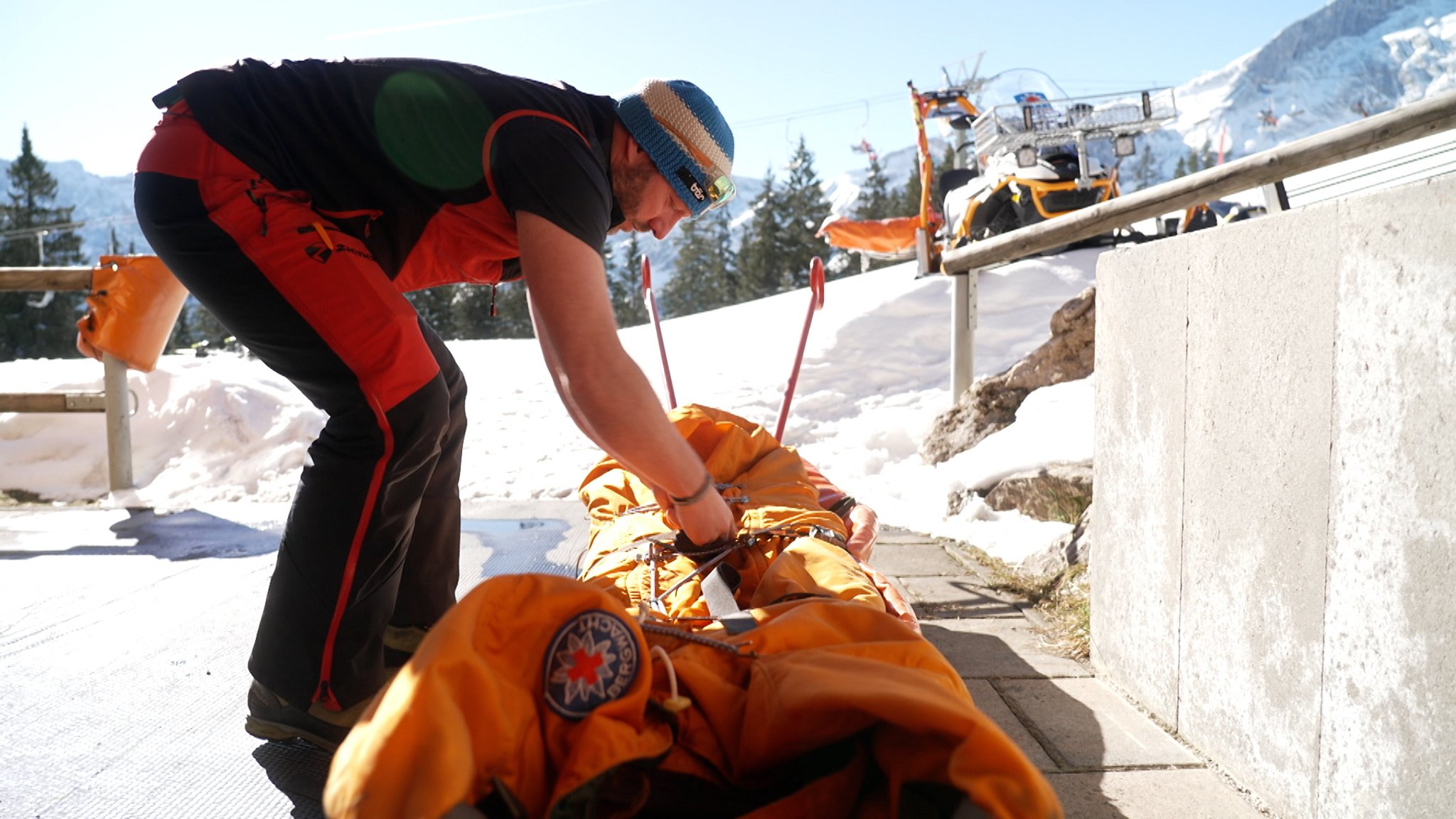 Angehöriger der Bergwacht beim Zuschnüren eines Akias 