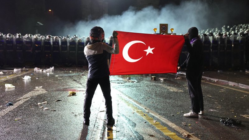 Demonstranten mit einer türkischen Flagge stehen Polizisten gegenüber. | Bild: picture alliance / CTK | Pavel Nemecek Demonstranten mit einer türkischen Flagge stehen Polizisten gegenüber.