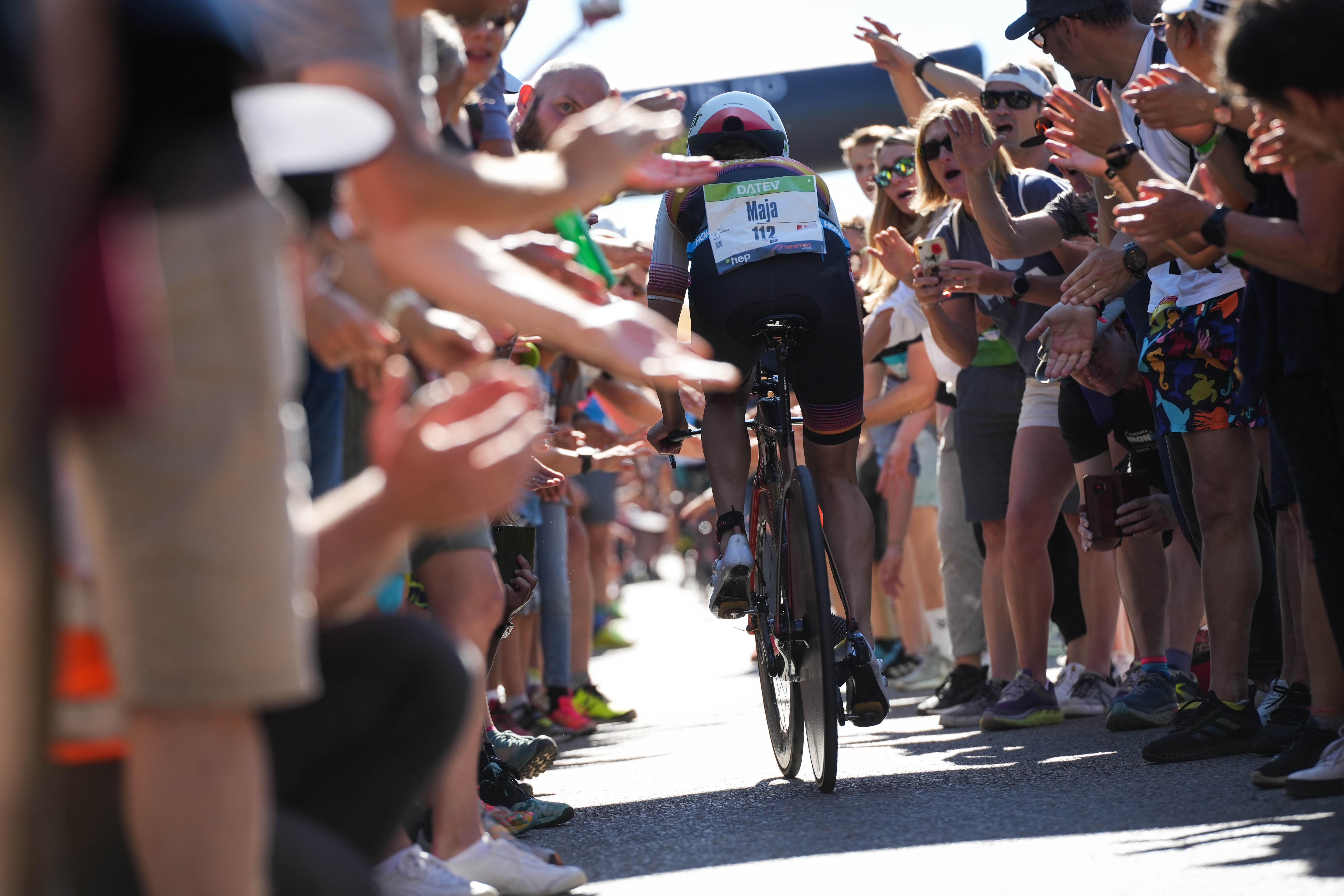 Radfahrerin wird am Solarer Berg von vielen Menschen angefeuert