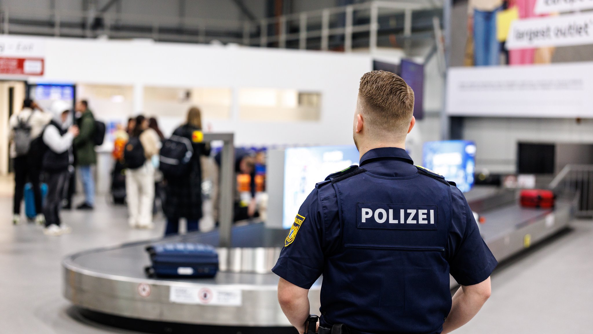 Ein Polizist vor dem Gepäckband am Flughafen Memmingen | Bild: picture alliance/dpa | Matthias Balk Ein Polizist vor dem Gepäckband am Flughafen Memmingen