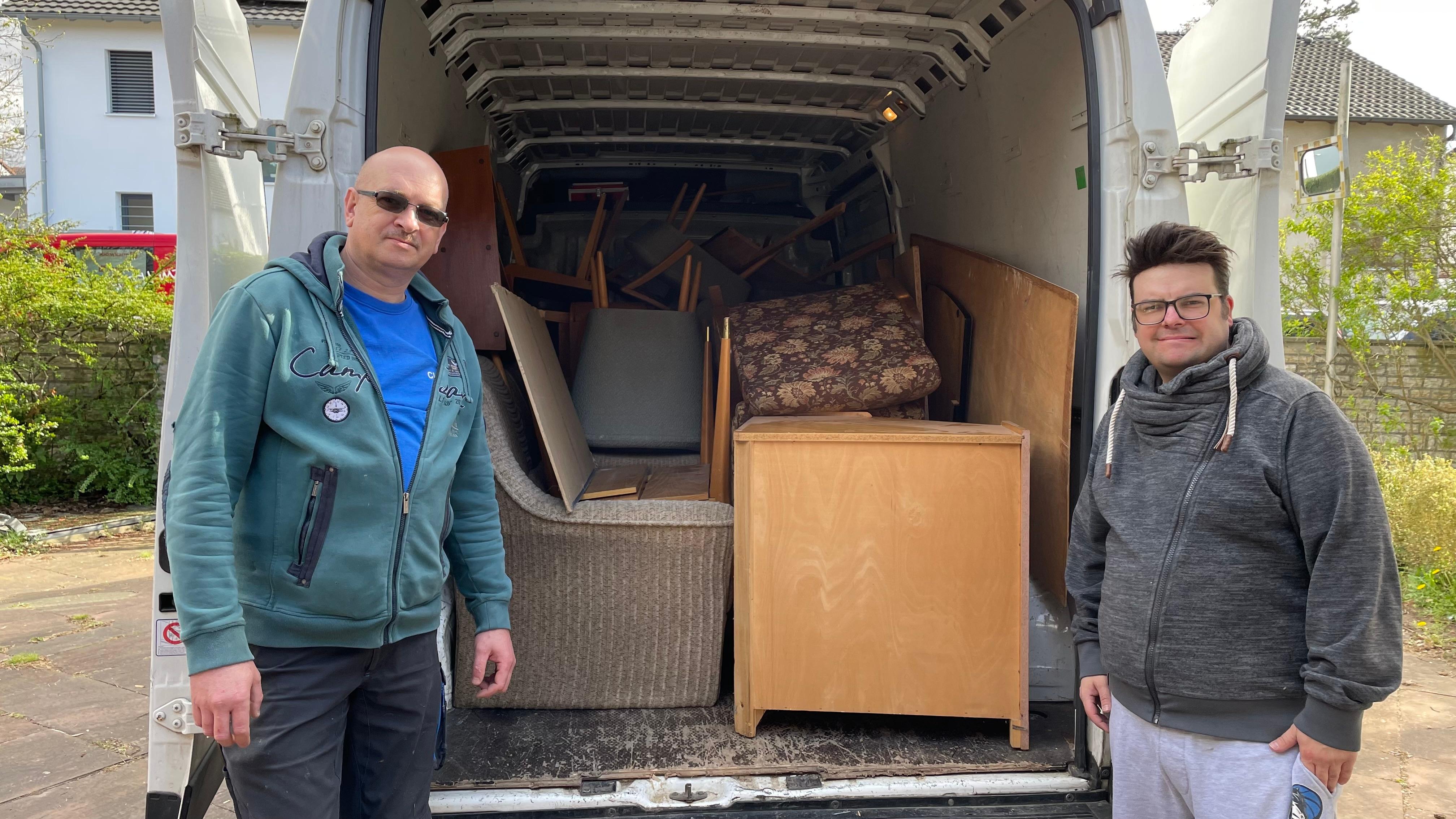 Zwei Männern vor Möbel in einem Kastenwagen.