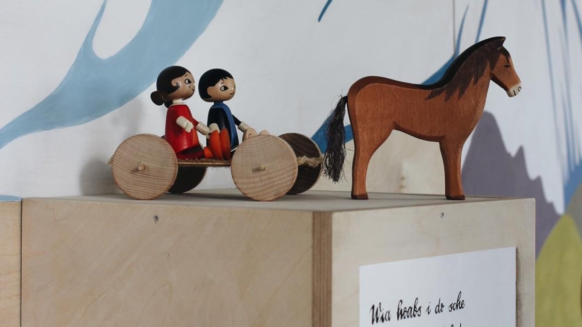 Ausstellungsgegenstände: Pferd aus Holz mit Kutsche.
