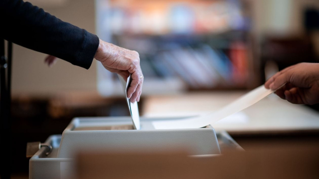 Ein Mensch wirft seinen Wahlzettel in eine Wahlurne (Archivbild)