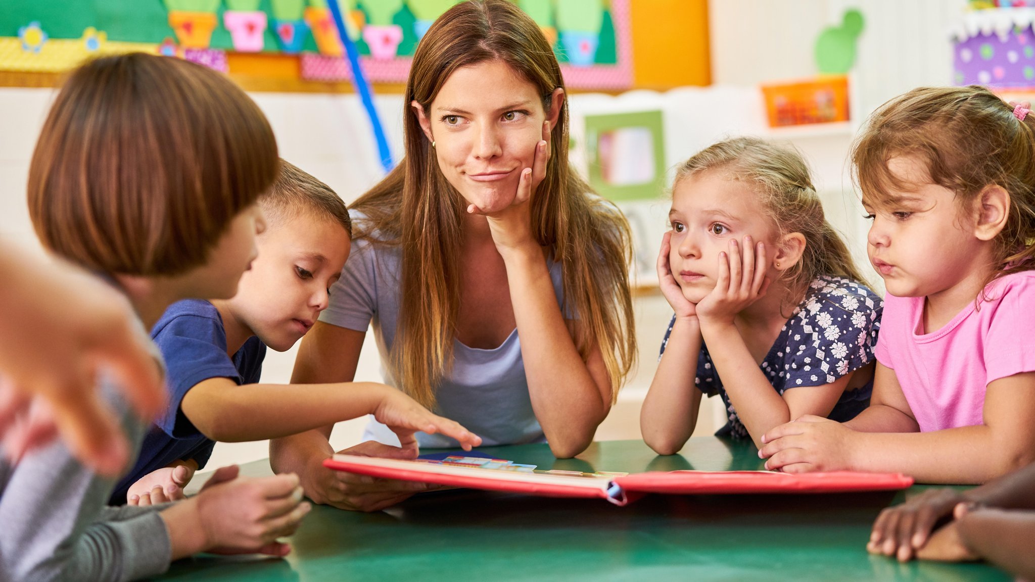Symbolbild: Eine junge Frau am Tisch umringt von vier Kindern im Kita-Alter. | Bild: picture alliance / Robert Kneschke Symbolbild: Eine junge Frau am Tisch umringt von vier Kindern im Kita-Alter.