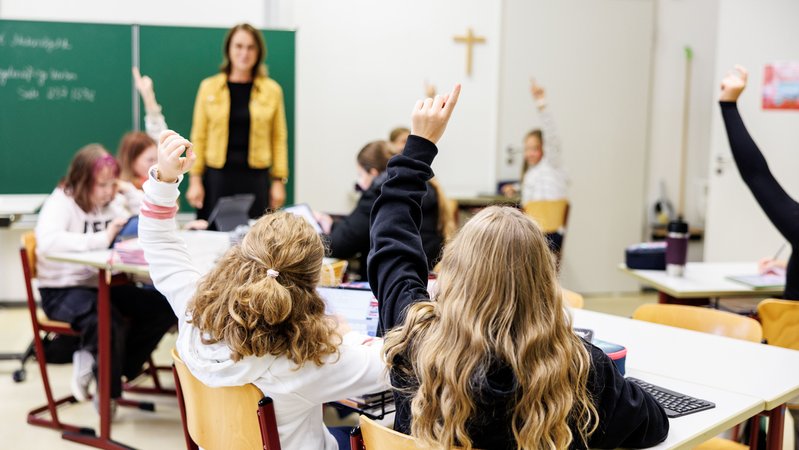 (Symbolbild) Eine Lehrkraft steht an der Tafel, mehrere Schülerinnen melden sich. | Bild: picture alliance / dpa | Matthias Balk (Symbolbild) Eine Lehrkraft steht an der Tafel, mehrere Schülerinnen melden sich.