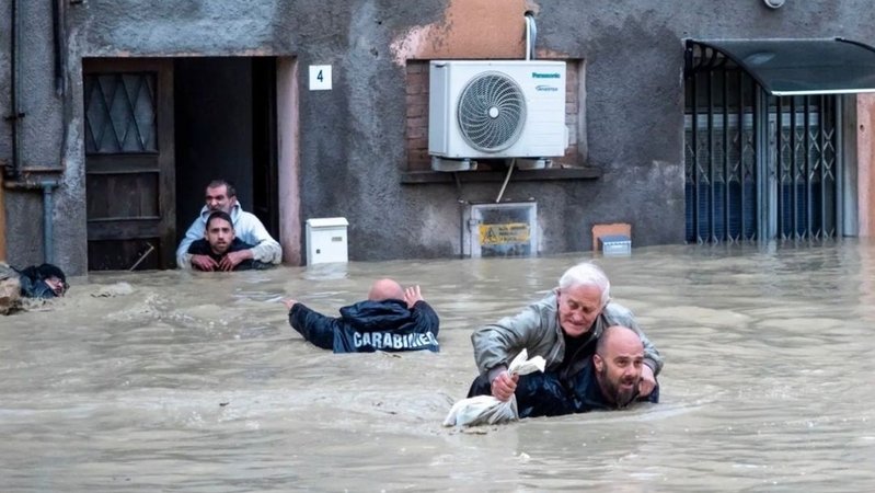 17.05.2023, Italien, Faenza: Carabinieri tragen Anwohner huckepack durch die überschwemmten Straßen. Die italienischen Regionen Emilia-Romagna und die Marken werden weiter von schweren Unwettern heimgesucht. 