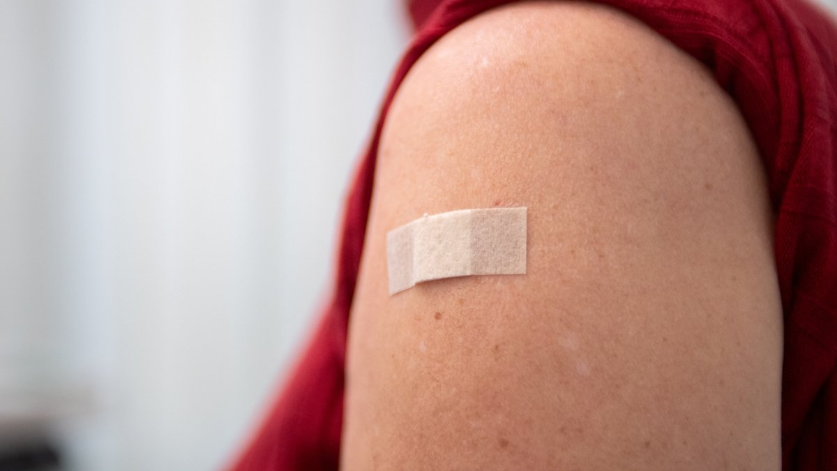 Ein Pflaster klebt am 20.09.2023 in Berlin nach einer Grippeimpfung auf der Schulter einer Frau.