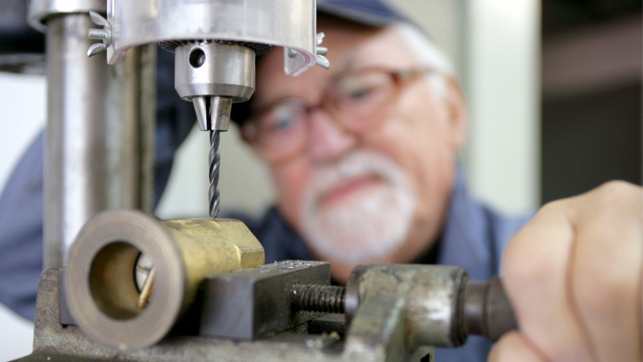 Berufstätiger Senior an einer Werkbank.