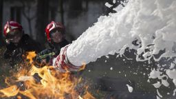 Mit Feuerlöschschaum bekämpfen Männer einen Brand (Symbolbild) | Bild:picture alliance / Zoonar (Symbolbild)
