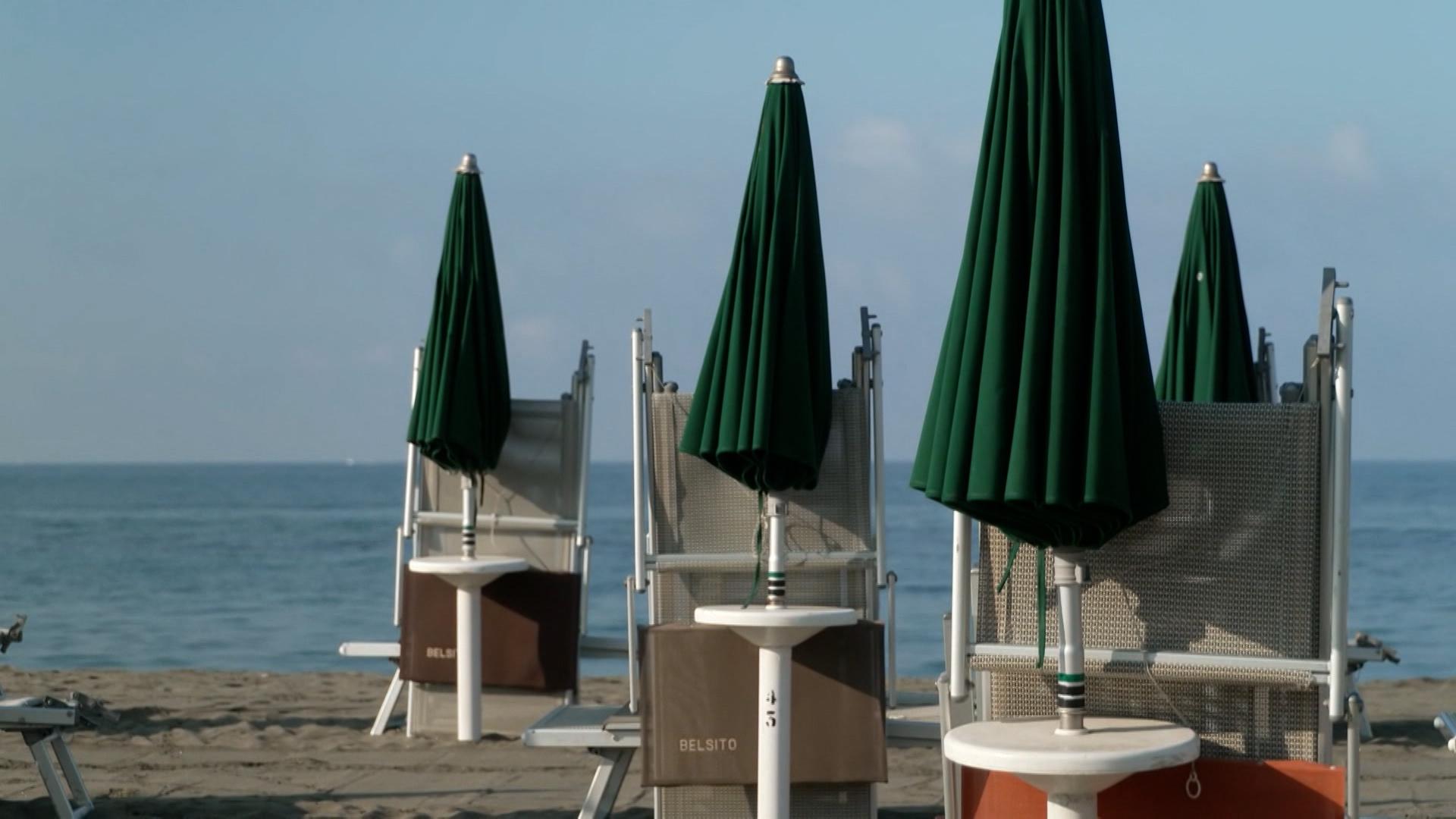 Geschlossene Sonnenschirme an einem Strand