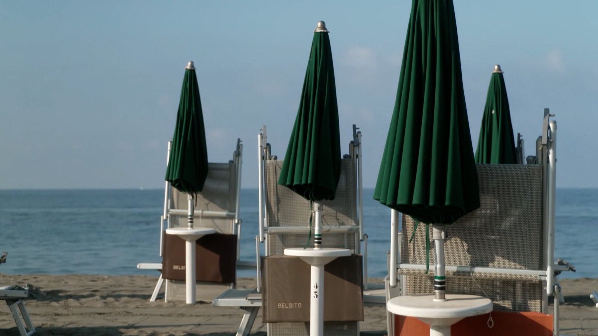 Geschlossene Sonnenschirme an einem Strand