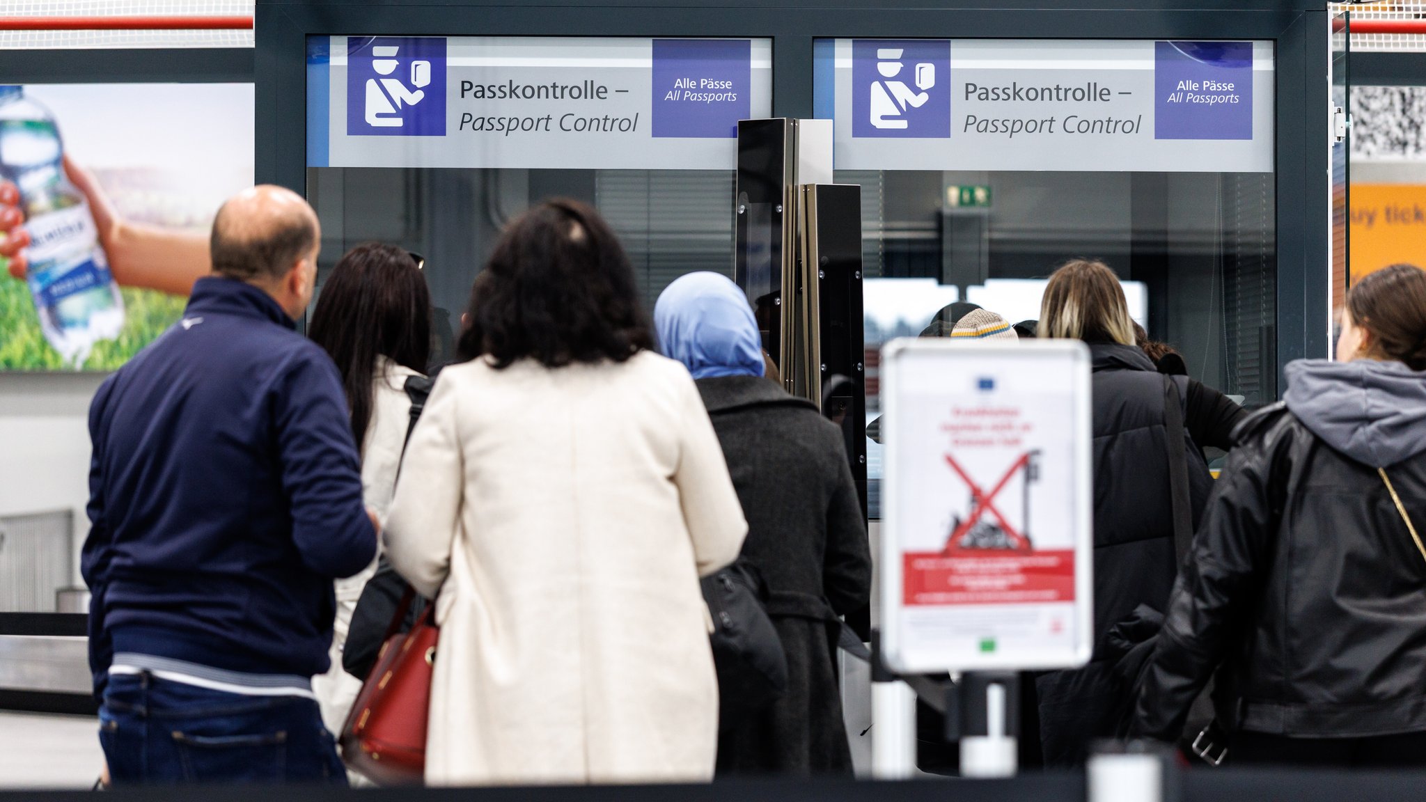 Menschen stehen nach ihrer Ankunft am Flughafen Memmingen in einer Schlange vor der Passkontrolle. | Bild: picture alliance / dpa | Matthias Balk Menschen stehen nach ihrer Ankunft am Flughafen Memmingen in einer Schlange vor der Passkontrolle.