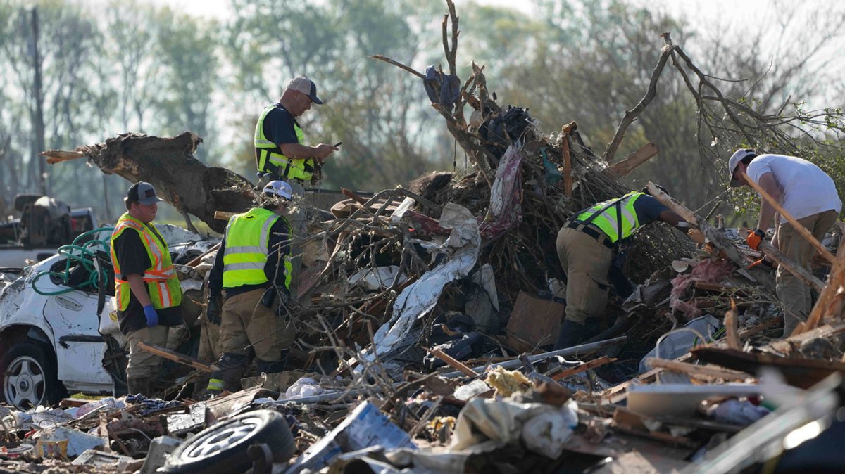 Rettungskräfte klettern durch einen von einem Tornado zerstörten Wohnmobilpark und suchen nach Leichen