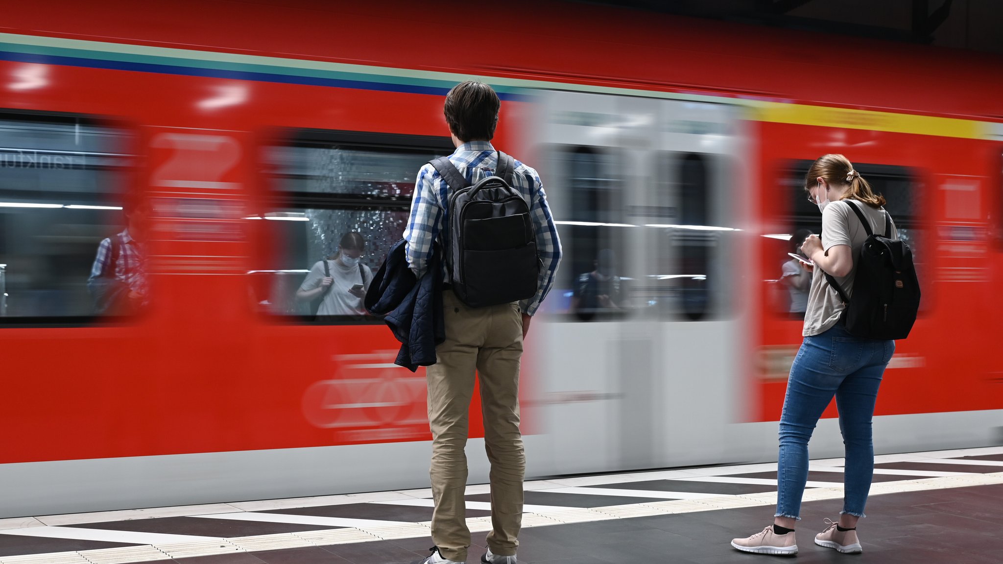 Zugreisende warten auf die Einfahrt einer S-Bahn