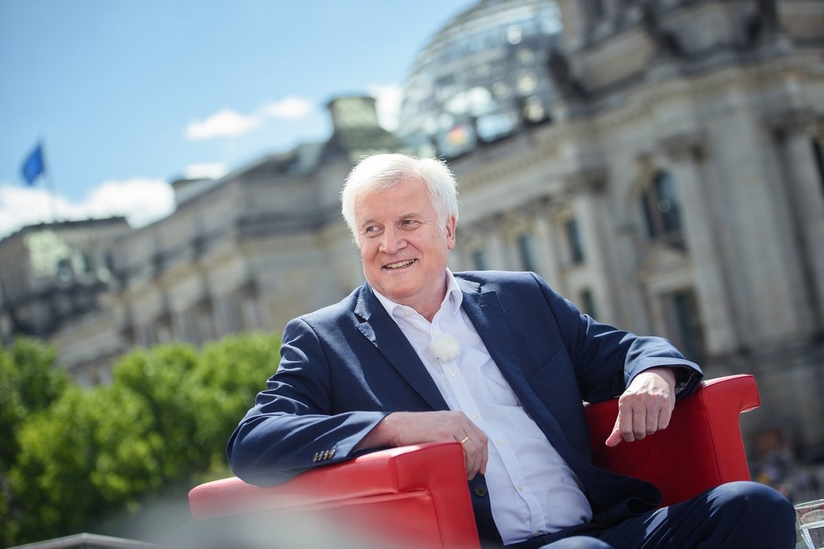  Horst Seehofer (CSU), Bundesinnenminister, sitzt vor Beginn der Aufzeichnung des ARD-Sommerinterviews vor der Kulisse des Reichstagsgebäudes.