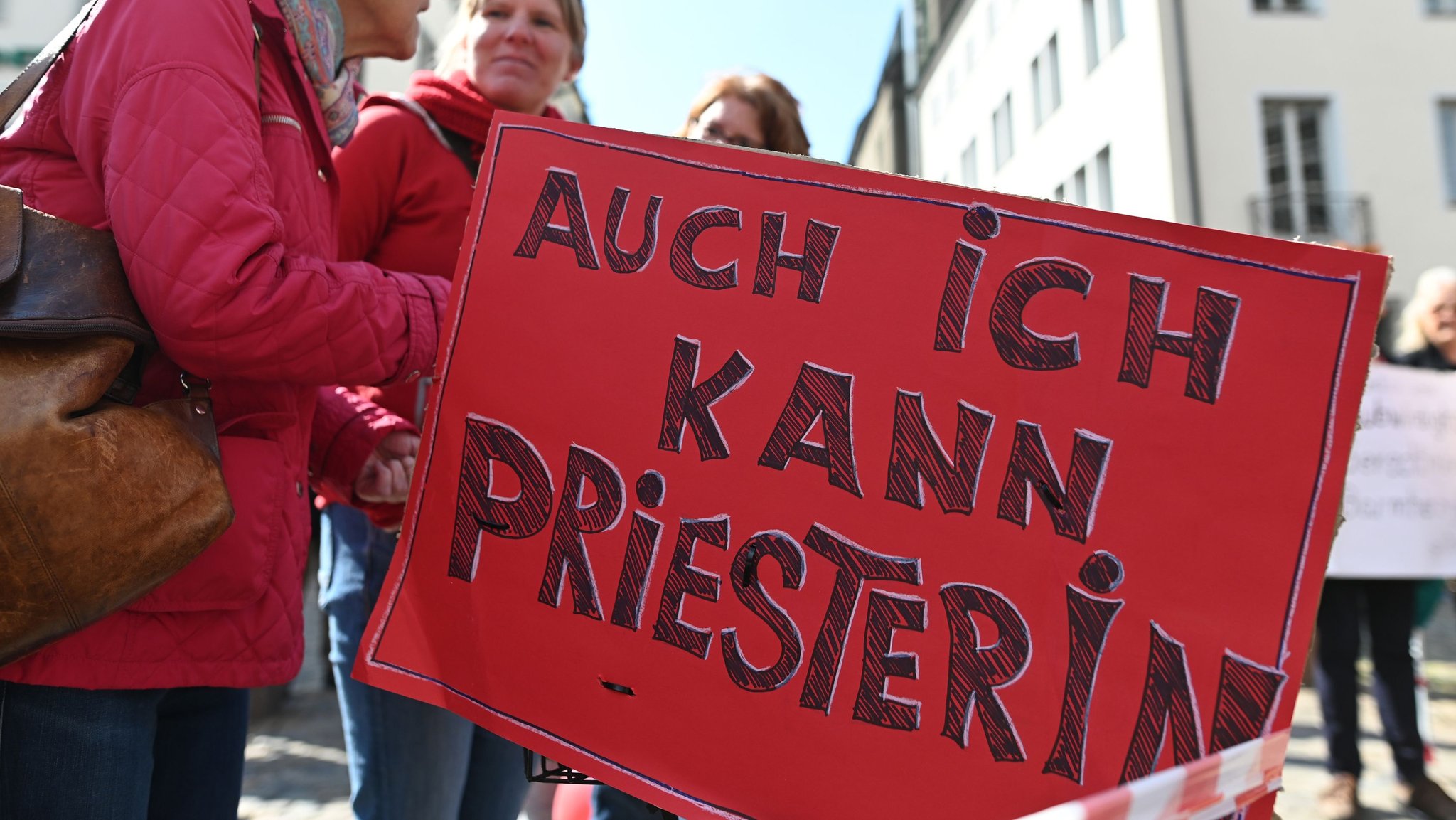 Protestplakat auf dem steht "Auch ich kann Priesterin".