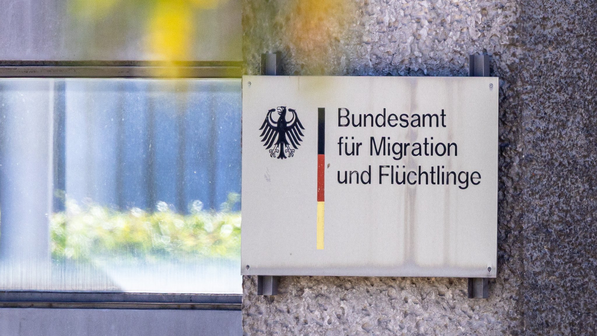 Ein Schild mit Bundesadler und den Farben Schwarz-Rot-Gold weist auf das Bundesamt für Migration und Flüchtlinge (BAMF) hin. | Bild: picture alliance / Eibner-Pressefoto | Eibner-Pressefoto/Ardan Fuessman Ein Schild mit Bundesadler und den Farben Schwarz-Rot-Gold weist auf das Bundesamt für Migration und Flüchtlinge (BAMF) hin.