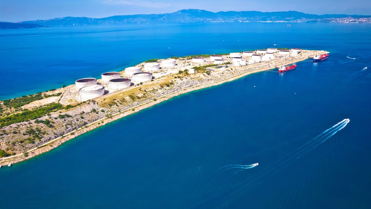 LNG-Terminal mit großen Tanks auf der kroatischen Insel Krk, zwei Tanker ankern davor.