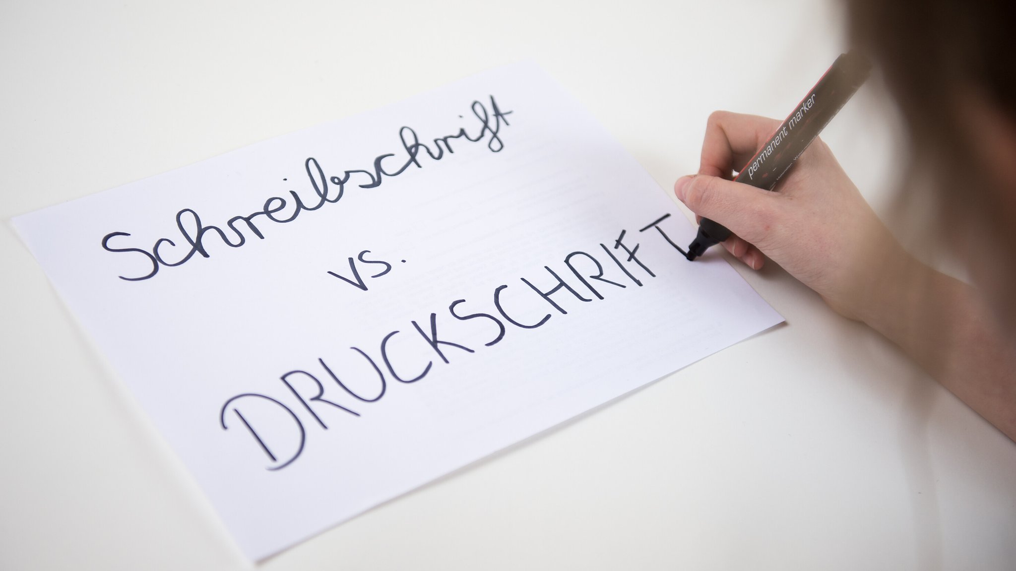 (Symbolbild) Auf einem Blatt steht "Schreibschrift vs. Druckschrift" | Bild: picture alliance / dpa (Symbolbild) Auf einem Blatt steht "Schreibschrift vs. Druckschrift"