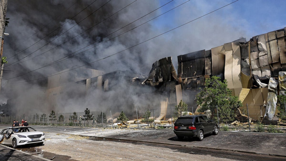 (Archivbild vom 24.06.24) Rauch steigt aus einem durch einen russischen Raketenangriff zerstörten Lagerhaus auf. 