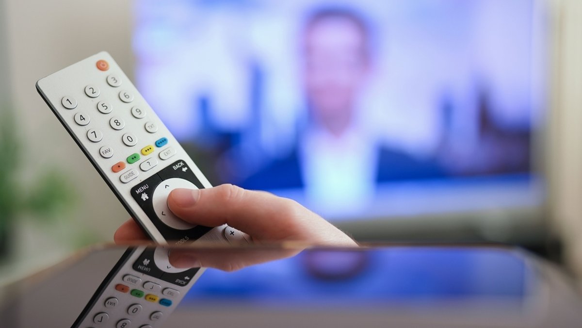 Ein Mann drückt einen Knopf auf der Fernbedienung seines Fernsehers. | Bild: dpa-Bildfunk/Marcus Brandt Ein Mann drückt einen Knopf auf der Fernbedienung seines Fernsehers.