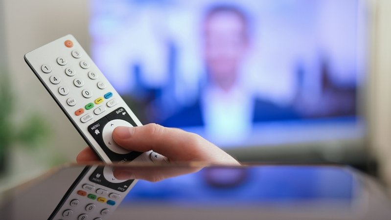 Ein Mann drückt einen Knopf auf der Fernbedienung seines Fernsehers. | Bild: dpa-Bildfunk/Marcus Brandt Ein Mann drückt einen Knopf auf der Fernbedienung seines Fernsehers.