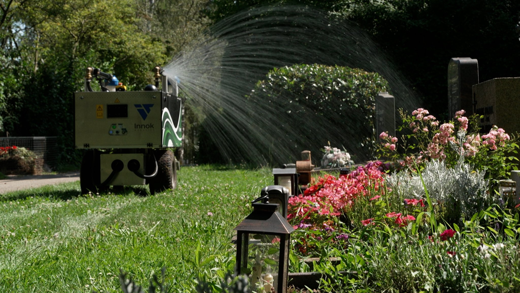 Ein Gießroboter im Einsatz auf einem Friedhof.