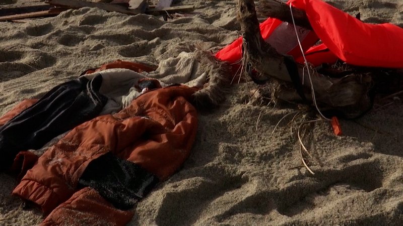 Eine Jacke und eine Rettungsweste liegen am Strand 