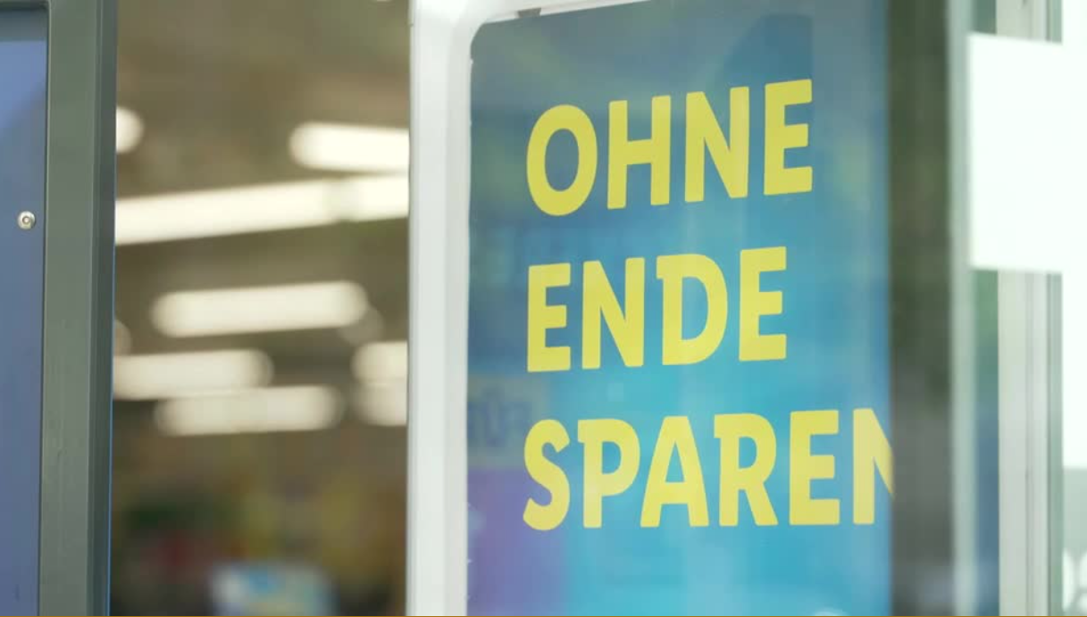 Eingangsbereich eines Discounters in München. Auf einem Plakat steht "Ohne Ende sparen".