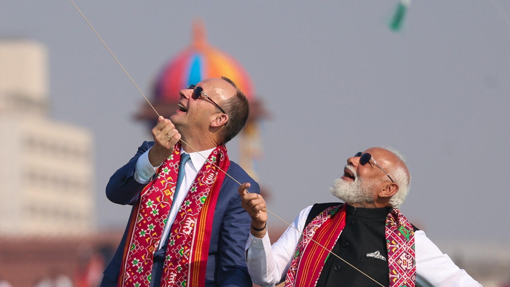 Friedrich Merz und Narendra Modi lassen einen Drachen steigen und schauen lachend nach oben. | Bild: picture alliance / Anadolu | Press Information Bureau (PIB) Friedrich Merz und Narendra Modi lassen einen Drachen steigen und schauen lachend nach oben.