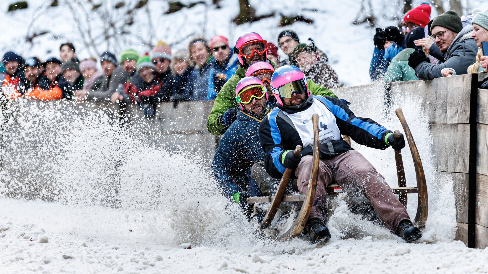 Die Gruppe "Partnachalm" fährt beim Hornschlittenrennen mit ihrem Schlitten den Hang hinunter.