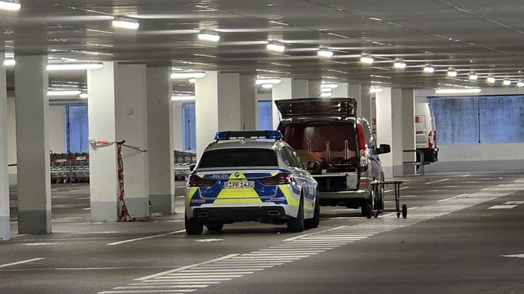 Einsatzkräfte der Kriminalpolizeiinspektion Regensburg arbeitet in einer Tiefgarage eines Baumarkts. 