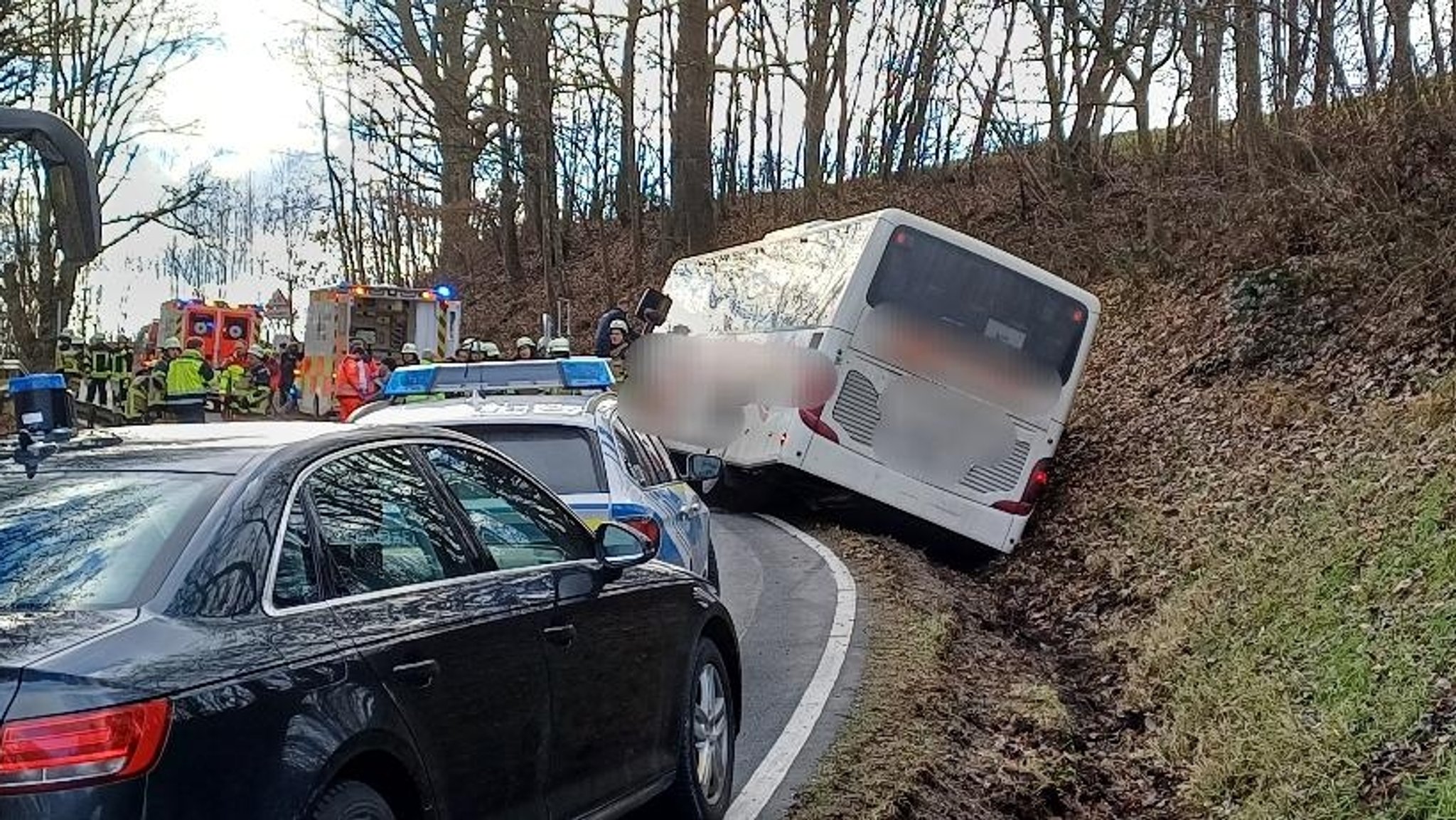 Der seitlich in den Graben gerutschte Schulbus. Zahlreiche Einsatzkräfte waren vor Ort.