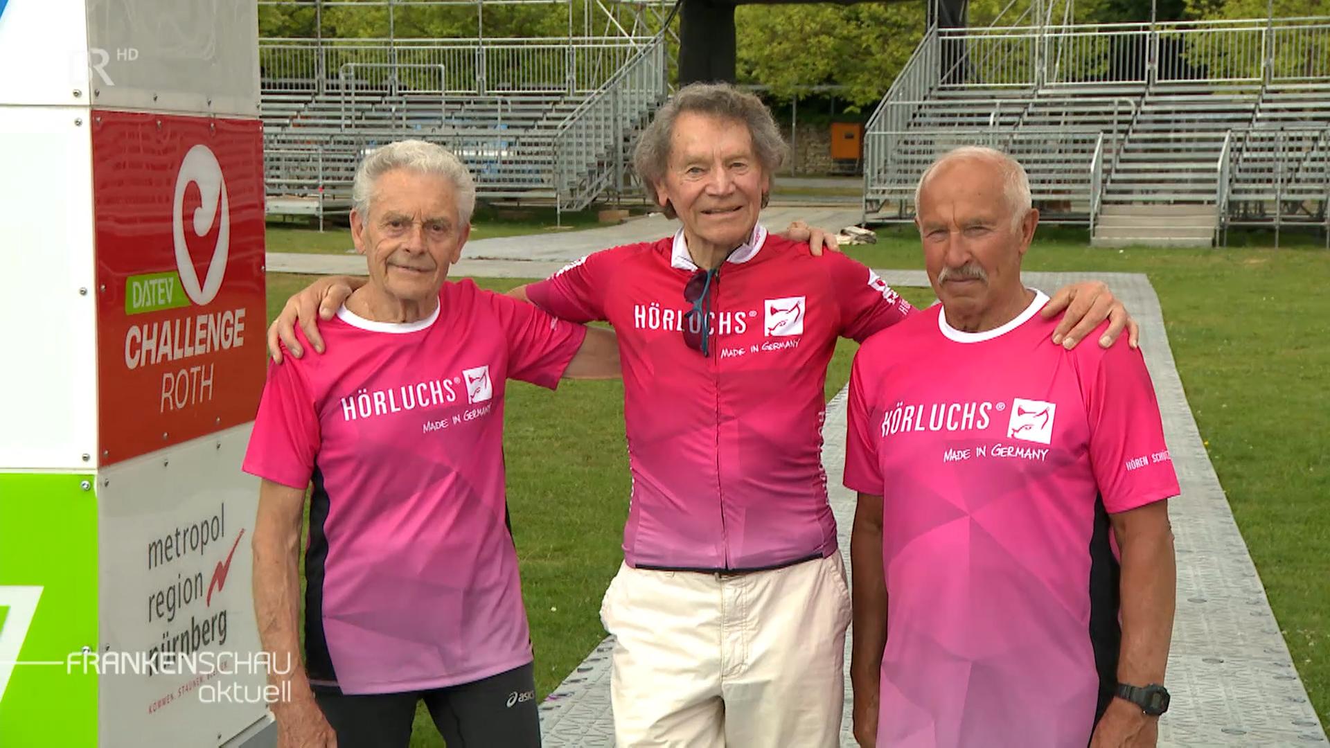 Drei ältere Männer im pinken Sportshirt
