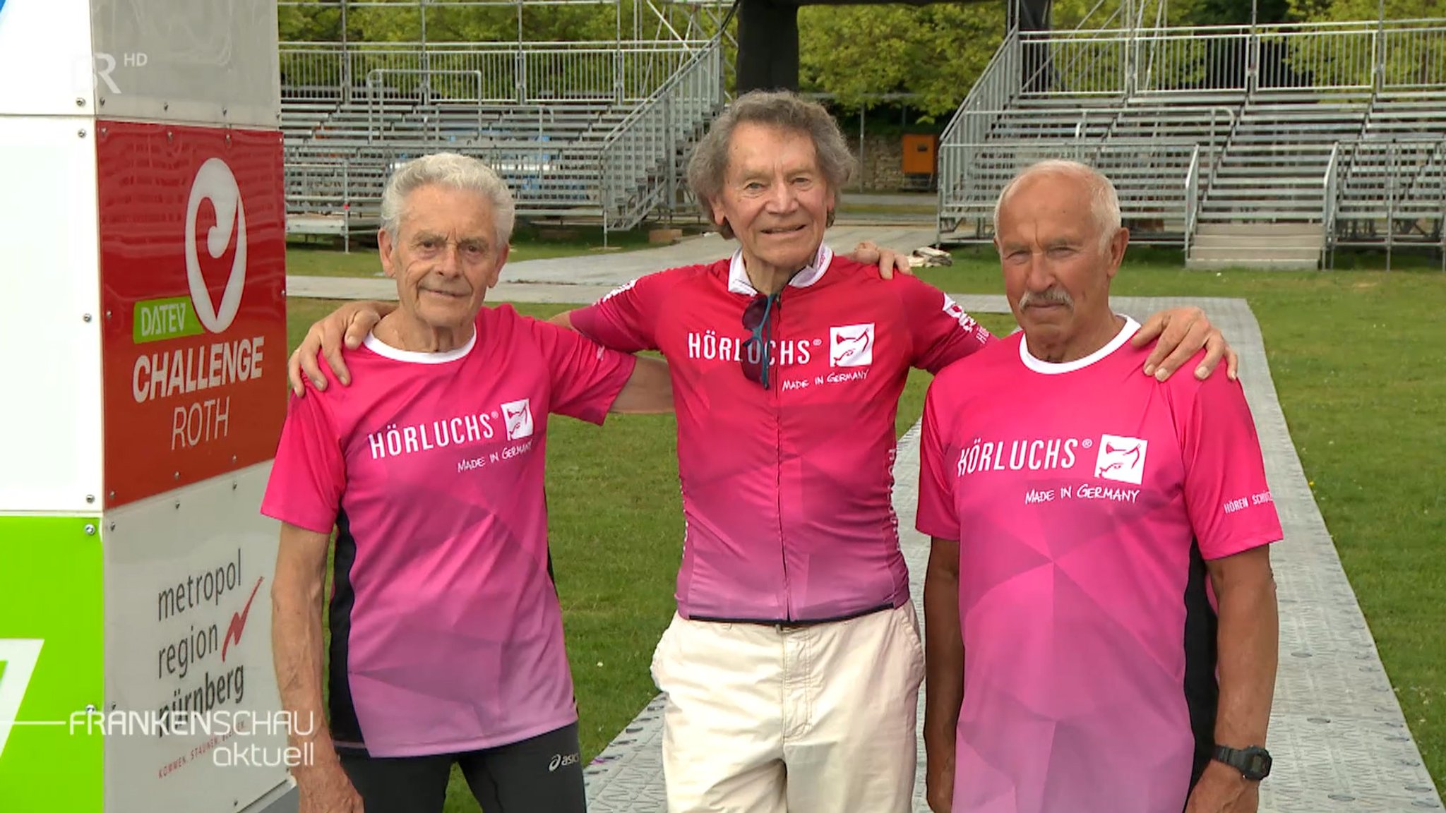 Drei ältere Männer im pinken Sportshirt