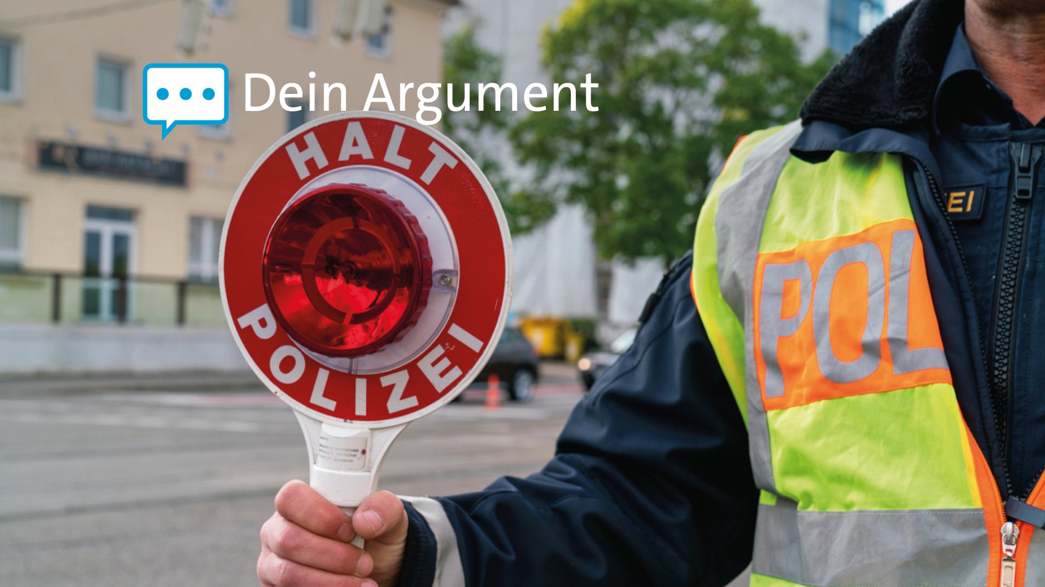 Ein Polizist hält eine Kelle mit der Aufschrift "Halt Polizei" in der Hand. 