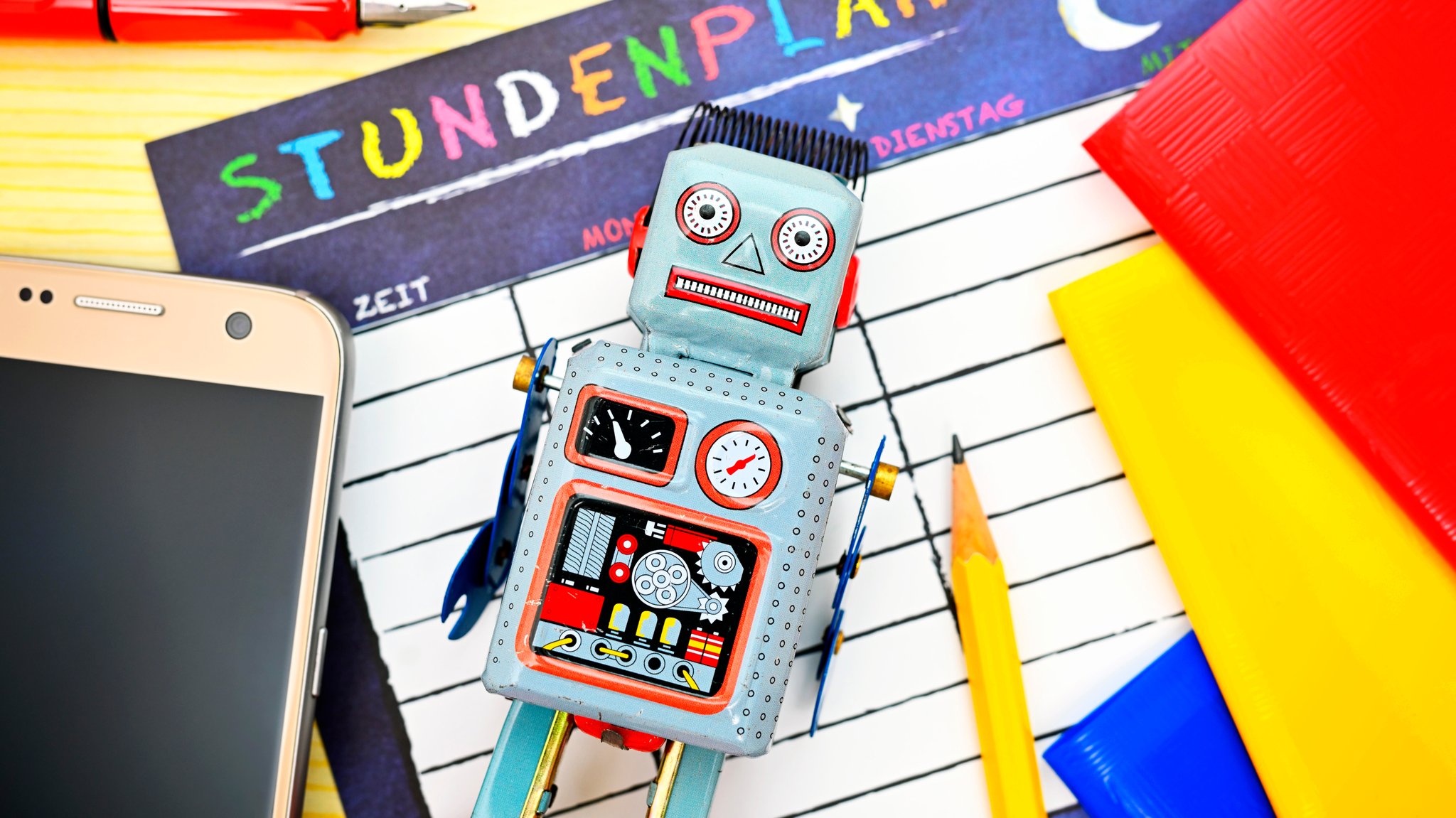 Symbolbild: Roboter umgeben von Schulutensilien.