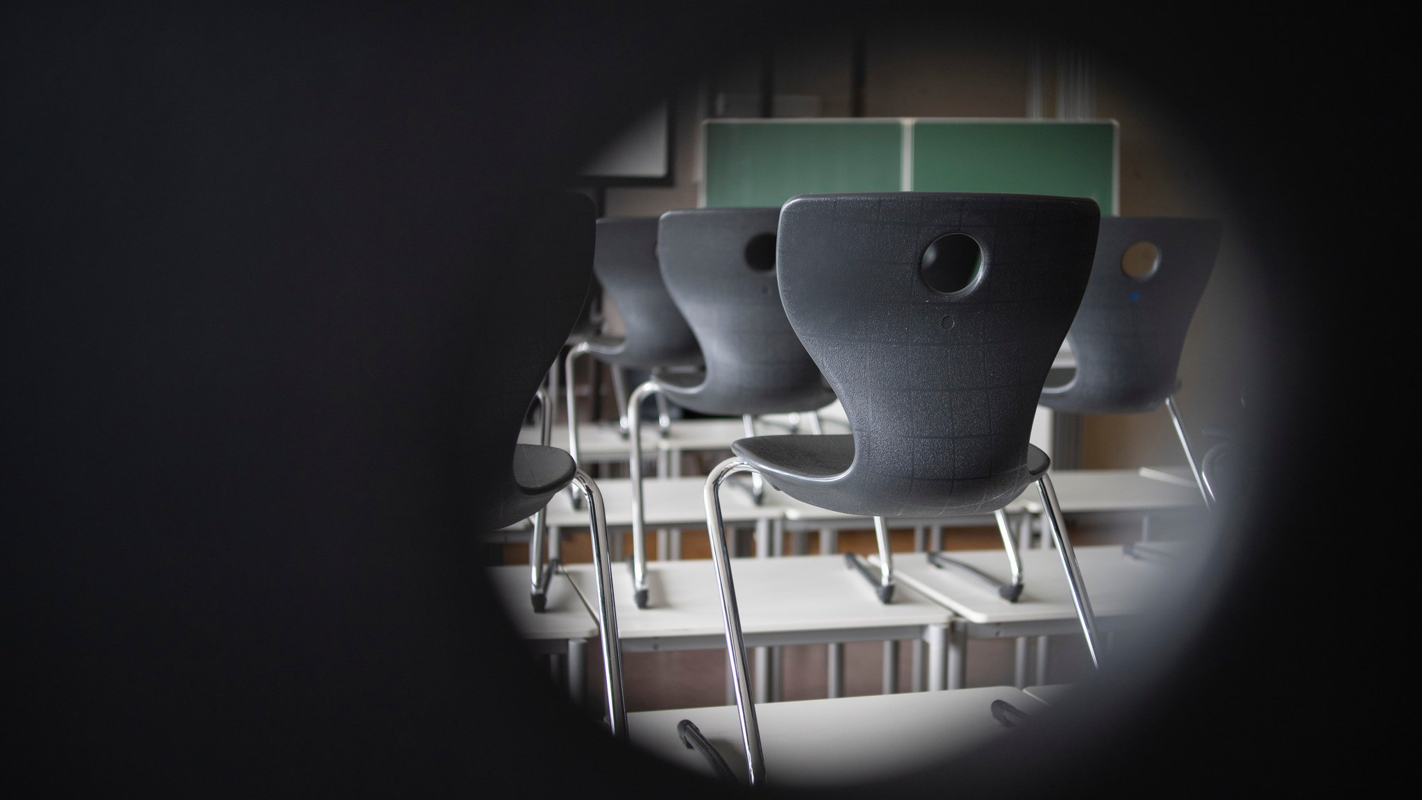 Stühle und eine Tafel sind in einem Schulraum