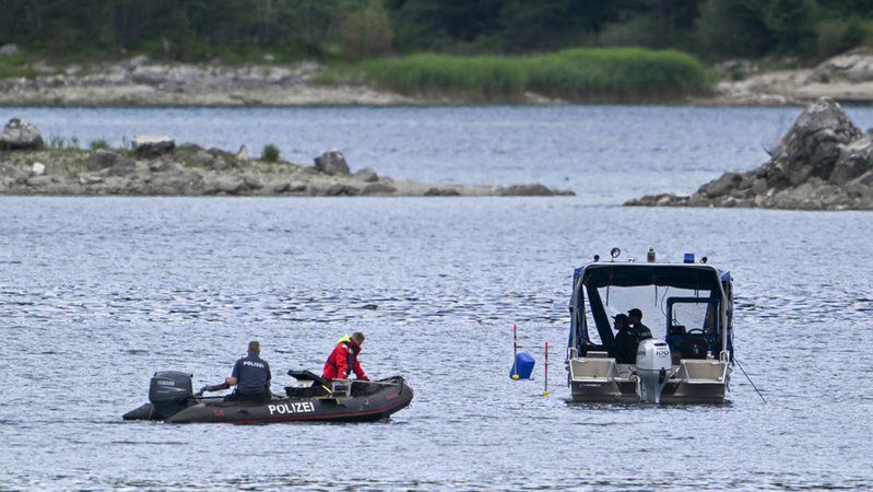 07.07.2025, Bayern, Grainau: Polizeitaucher mit Booten suchen auf dem Eibsee nach zwei vermissten Personen. Ein 33 Jahre alter Mann und sein sechsjähriger Sohn sind nach Polizeiangaben in dem See untergegangen. Sie waren auf einem Tretboot unterwegs. (zu dpa: «Tretboot-Unglück: Vater und Sohn werden weiter gesucht») Foto: Peter Kneffel/dpa +++ dpa-Bildfunk +++ | Bild: dpa-Bildfunk/Peter Kneffel 07.07.2025, Bayern, Grainau: Polizeitaucher mit Booten suchen auf dem Eibsee nach zwei vermissten Personen. Ein 33 Jahre alter Mann und sein sechsjähriger Sohn sind nach Polizeiangaben in dem See untergegangen. Sie waren auf einem Tretboot unterwegs. (zu dpa: «Tretboot-Unglück: Vater und Sohn werden weiter gesucht») Foto: Peter Kneffel/dpa +++ dpa-Bildfunk +++
