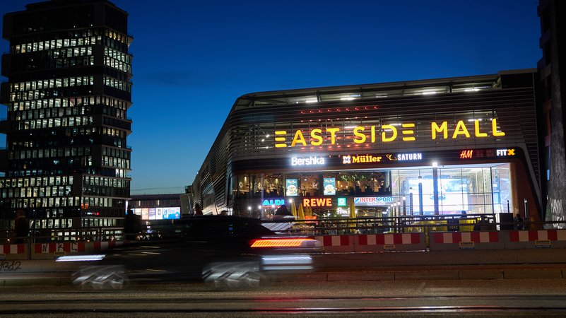 Blick zur Blauen Stunde am frühen Abend auf die Einkaufspassage East Side in Berlin | Bild: picture alliance / Jörg Carstensen Blick zur Blauen Stunde am frühen Abend auf die Einkaufspassage East Side in Berlin