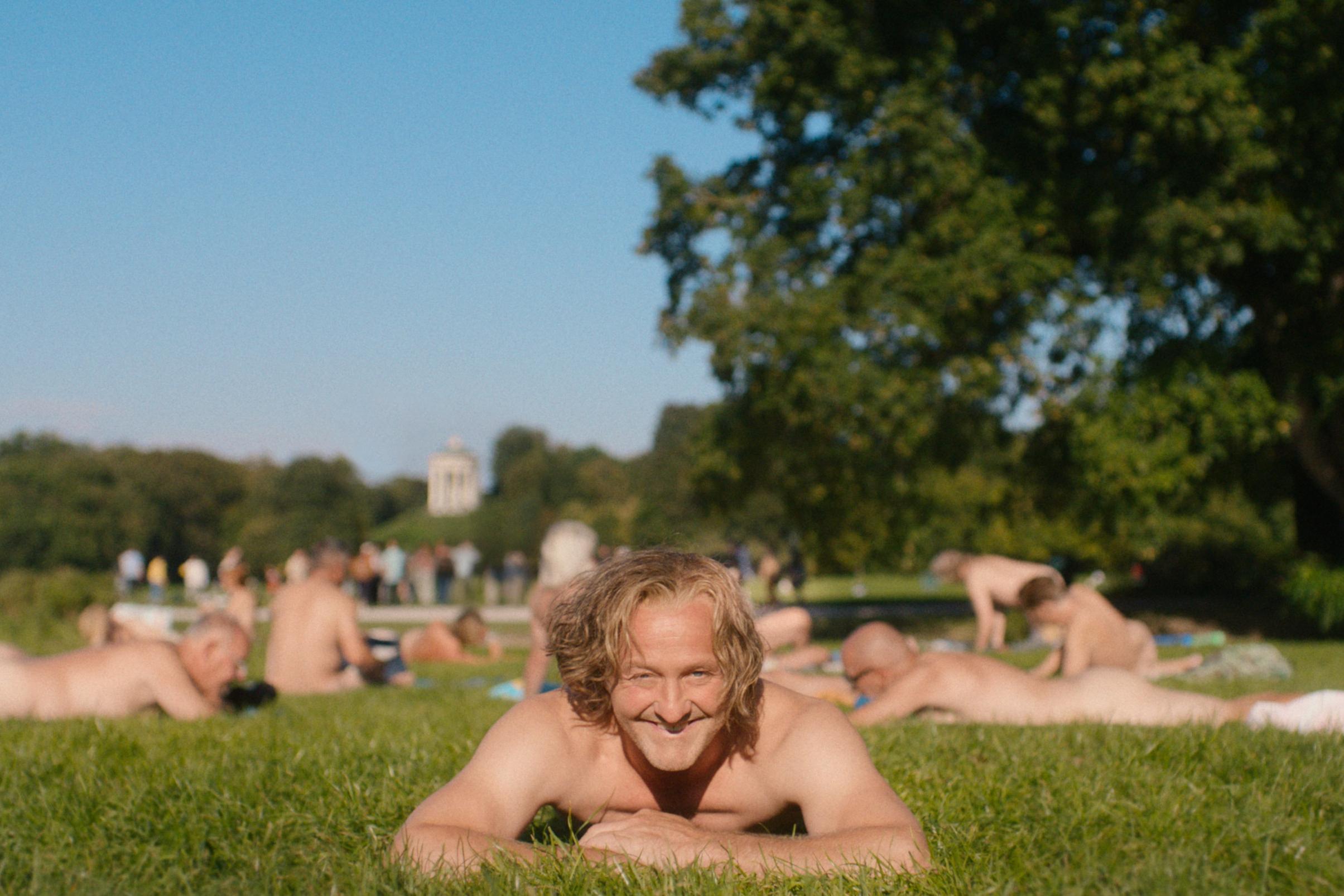 Maximilian Brückner spielt den Wiggerl und liegt in dieser Szene aus "Ein Münchner im Himmel" nackt im Englischen Garten.  | Bild:LEONINE Studios