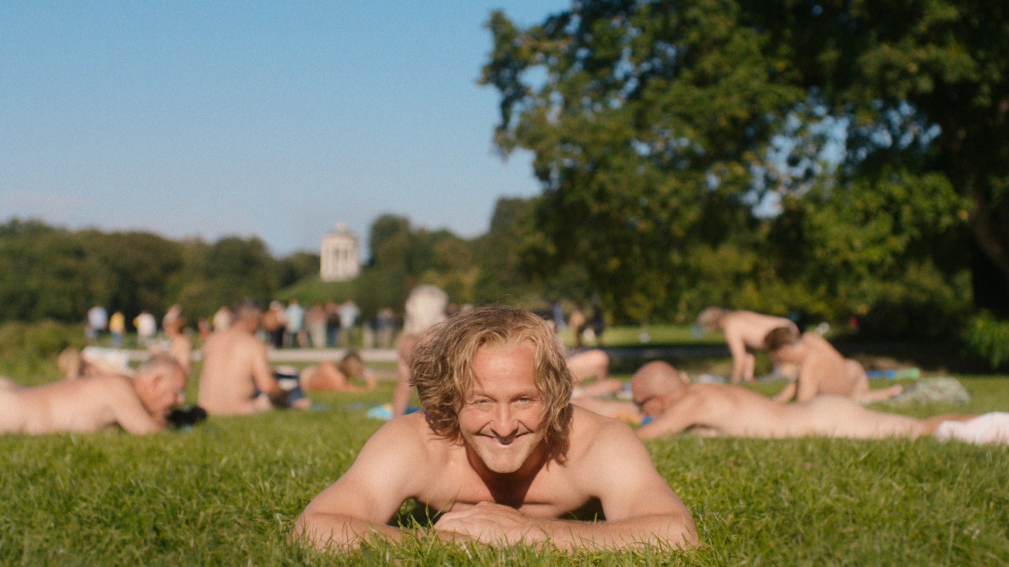 Maximilian Brückner spielt den Wiggerl und liegt in dieser Szene aus "Ein Münchner im Himmel" nackt im Englischen Garten. | Bild: LEONINE Studios Maximilian Brückner spielt den Wiggerl und liegt in dieser Szene aus "Ein Münchner im Himmel" nackt im Englischen Garten.