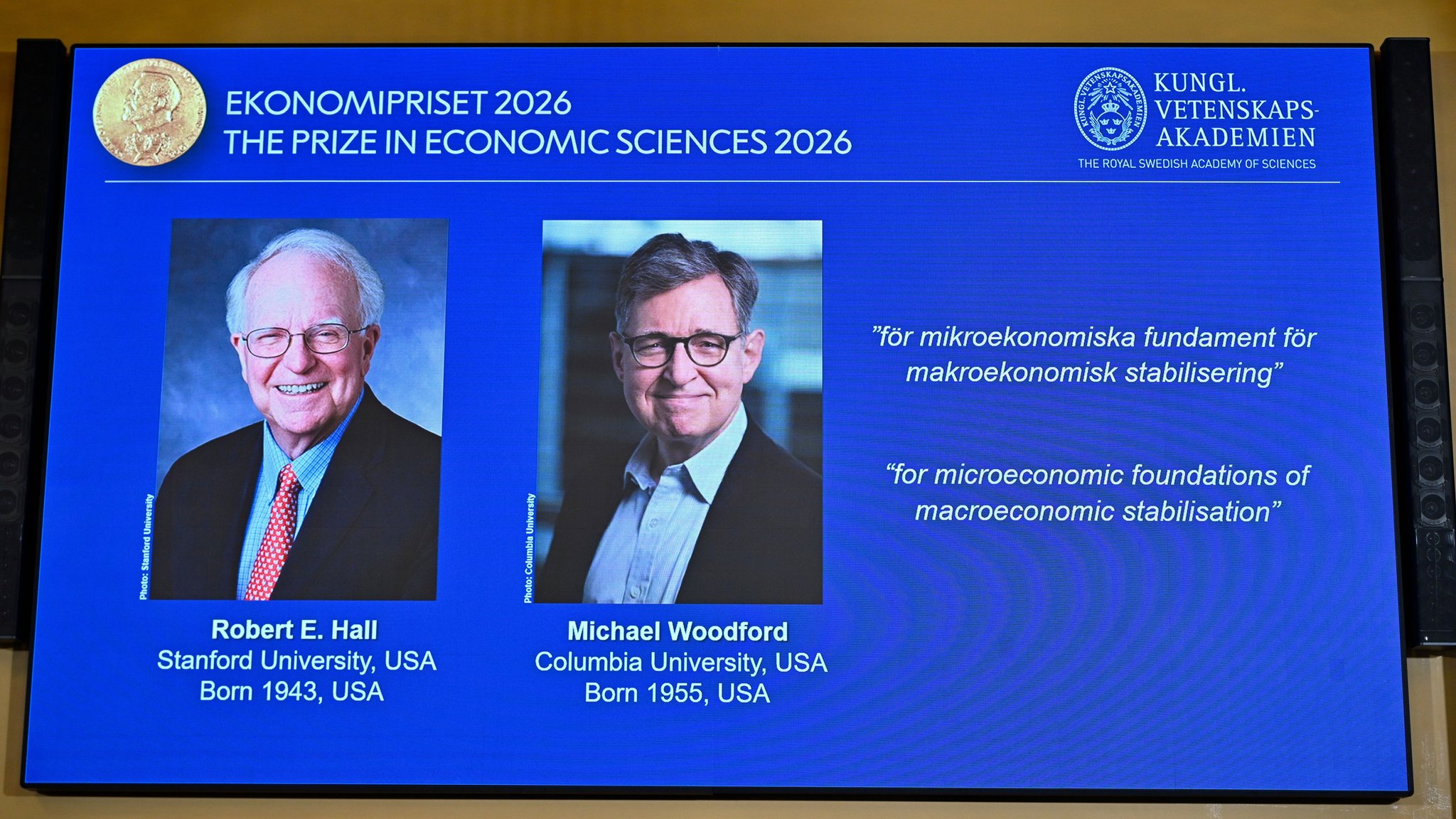 12.10.2026, Schweden, Stockholm: Porträts von Robert E. Hall und Michael Woodford werden auf der Leinwand gezeigt, als sie am 12. Oktober 2026, in der Königlich Schwedischen Akademie der Wissenschaften in Stockholm, Schweden, als Preisträger des von der Sveriges Riksbank gestifteten Preises für Wirtschaftswissenschaften zum Gedenken an Alfred Nobel bekannt gegeben werden. | Bild: picture alliance / TT NEWS AGENCY | Anders Wiklund/TT 12.10.2026, Schweden, Stockholm: Porträts von Robert E. Hall und Michael Woodford werden auf der Leinwand gezeigt, als sie am 12. Oktober 2026, in der Königlich Schwedischen Akademie der Wissenschaften in Stockholm, Schweden, als Preisträger des von der Sveriges Riksbank gestifteten Preises für Wirtschaftswissenschaften zum Gedenken an Alfred Nobel bekannt gegeben werden.