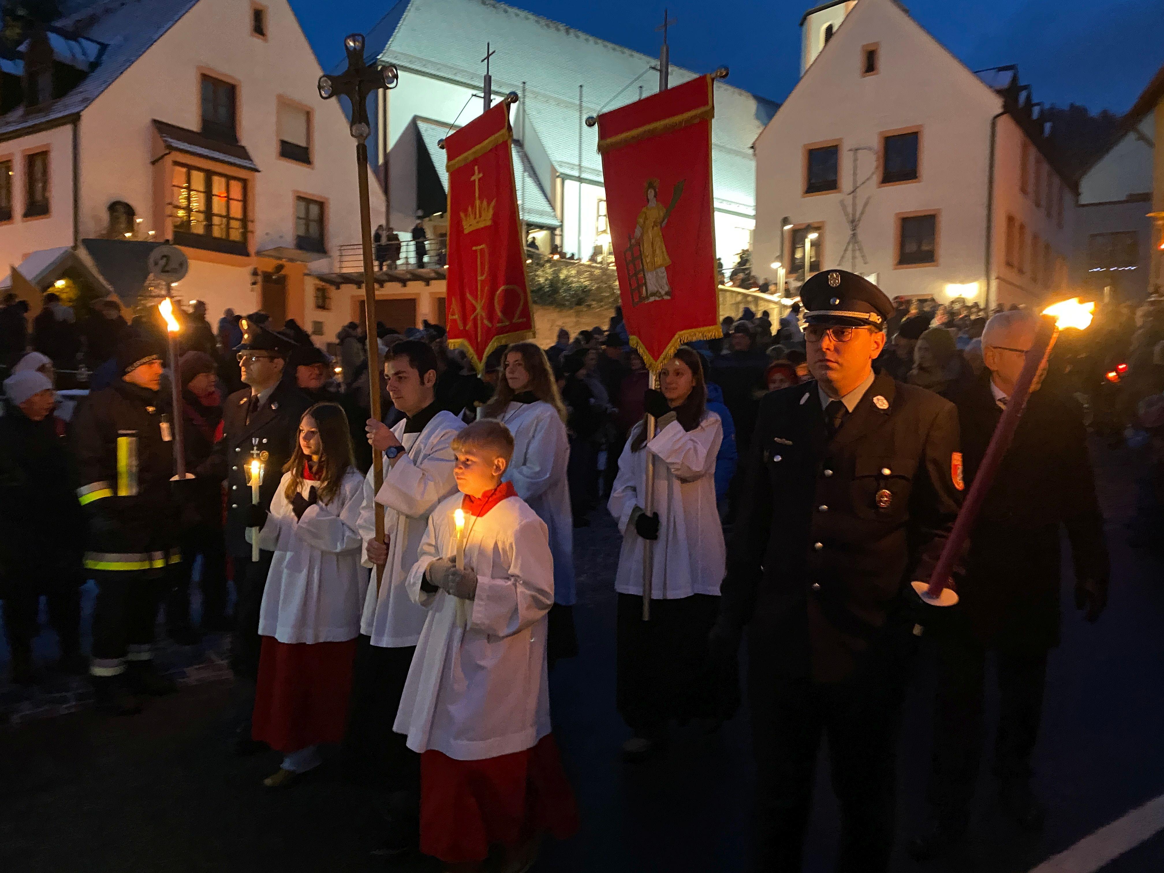 Eine Prozession zeiht nachts durch einen Ort. 